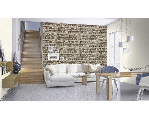 Wohnzimmer mit Steintreppenhaus, Couch, Esstisch und Wand in Steinoptik