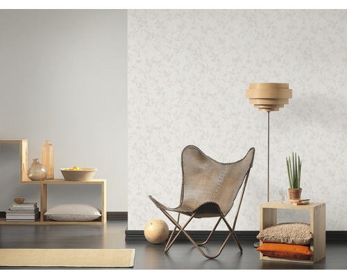 Salon lumineux avec papier peint à motifs, fauteuil et étagères en bois