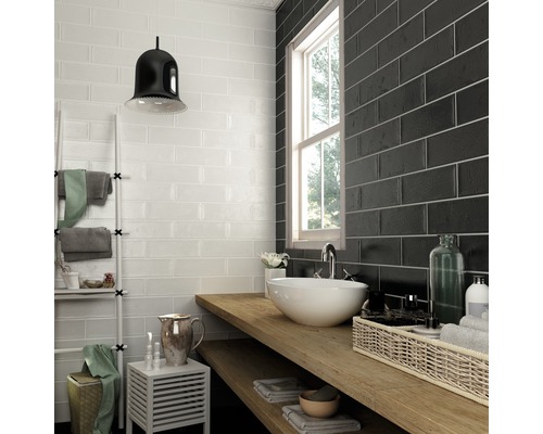 Badezimmer mit weißen und schwarzen rechteckigen Wandfliesen, Waschbecken und Holzablage