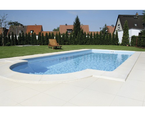 Piscine dans le jardin avec une chaise longue sur la pelouse