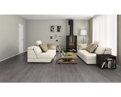 Wohnzimmer mit grauem Bodenbelag, Kamin und weißen Sofas.