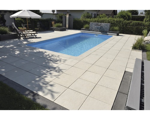 Piscine avec dalles en pierre et mobilier de jardin