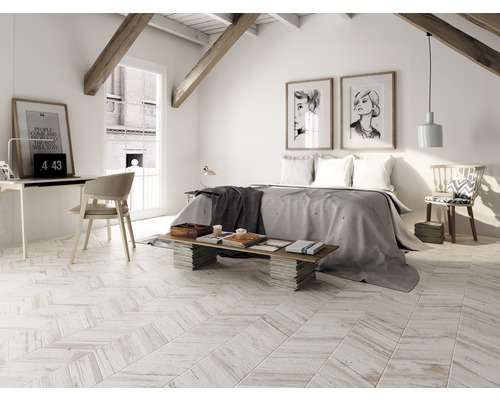 Chambre à coucher lumineuse dans les combles avec lit, bureau et poutres en bois