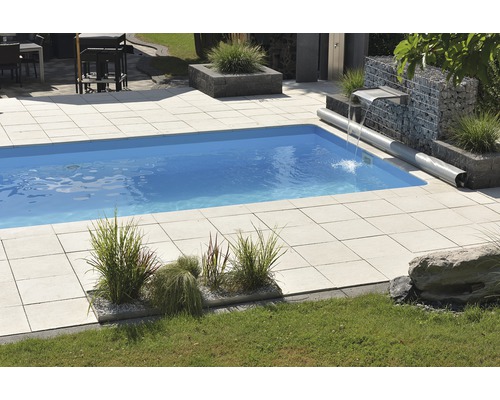 Piscine avec plaques de pierre et mur de gabions dans le jardin