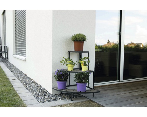 Étagère d''angle pour plantes avec plusieurs plantes en pot à l''extérieur