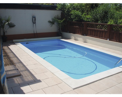 Piscine dans le jardin avec appareil de nettoyage de piscine