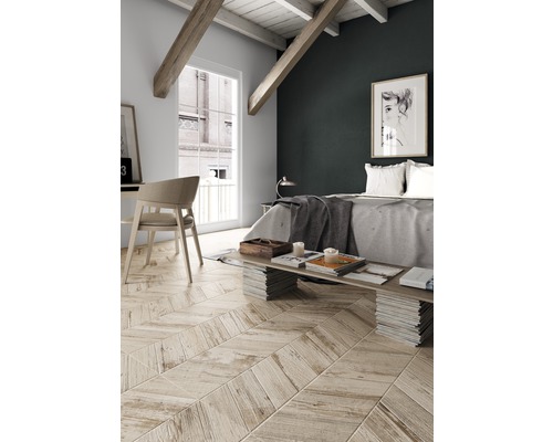 Chambre lumineuse avec toit mansardé, poutres en bois et parquet en point de Hongrie