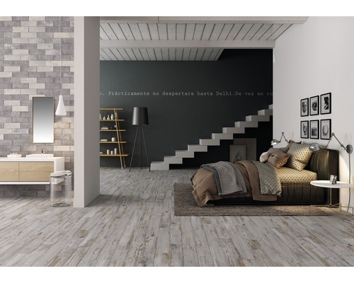 Pièce lumineuse avec parquet, lit, escalier et lavabo