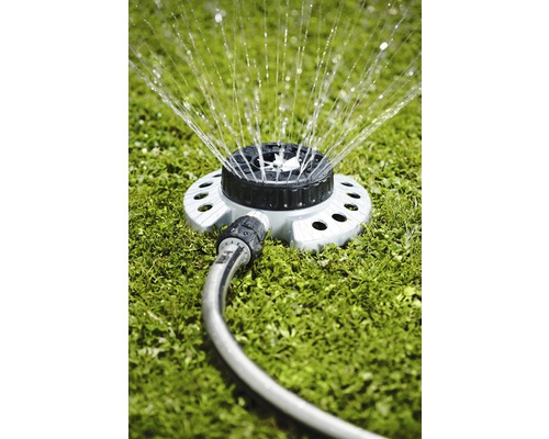 Rasensprenger mit Schlauch auf Rasen