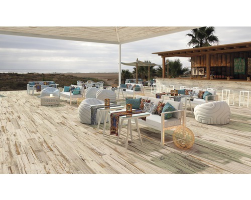 Espace extérieur avec lames de terrasse, mobilier de salon et bar