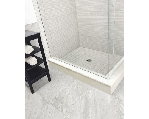 Badezimmer mit Dusche, gefliesten Wänden und einem Regal mit Handtüchern