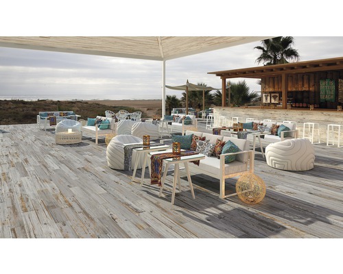 Espace extérieur avec plancher en bois, sièges et bar sur la plage