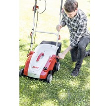 Un homme utilise un scarificateur de la marque AL-KO dans le jardin.