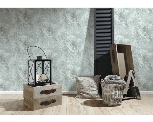 Espace de vie avec papier peint à motifs, lanterne, caisses en bois, coussin et panier à linge pour une atmosphère chaleureuse