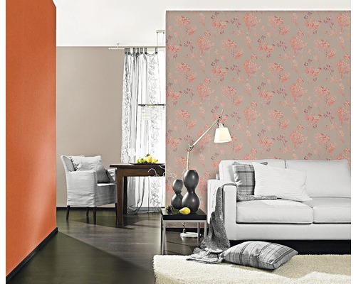 Wohnzimmer mit floral gemusterter Tapete, Sofa und Dekorationen für ein gemütliches Ambiente