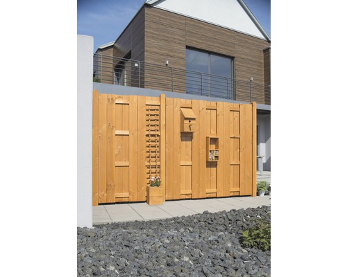 Clôture en bois avec jardinière intégrée, nichoir et hôtel à insectes dans le jardin