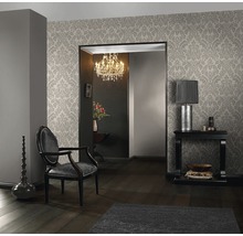 Elegantes Wohnzimmer mit gemusterter Tapete, Sessel und Dekorationsgegenständen