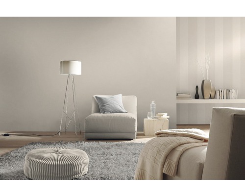 Wohnzimmer mit Sessel, Stehlampe, Teppich und dekorativen Elementen in neutralen Farbtönen.