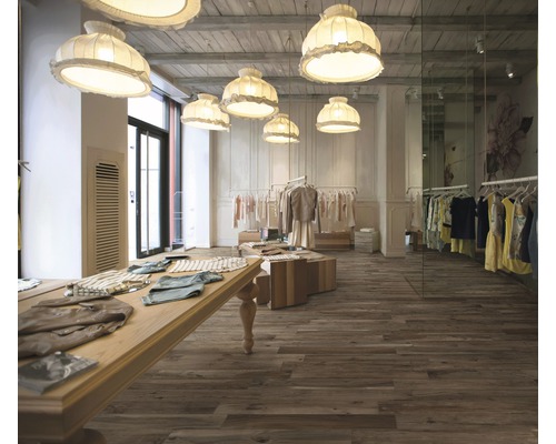 Vue intérieure d''un magasin de vêtements avec plancher en bois, portants à vêtements et lampes