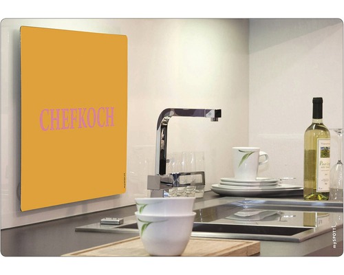 Küchenszene mit Spüle, Geschirr und Spritzschutzwand mit der Aufschrift Chefkoch