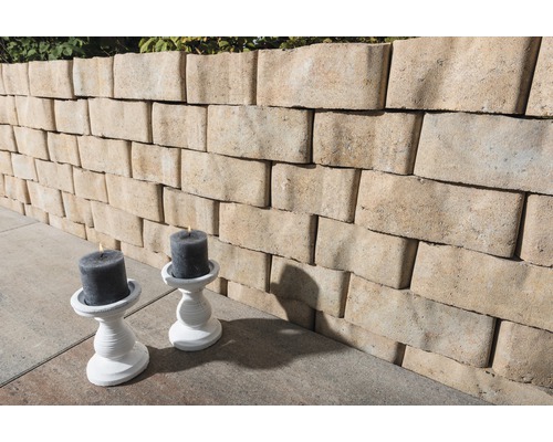 Eine Mauer aus Mauersteinen und zwei Kerzenständer mit Kerzen