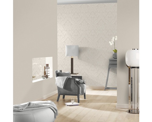 Helles Wohnzimmer mit gemusterter Tapete, Sessel und Lampe