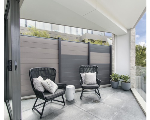 Balkon mit zwei Stühlen, Kissen, einem kleinen Tisch, Pflanzen und einem Zaun