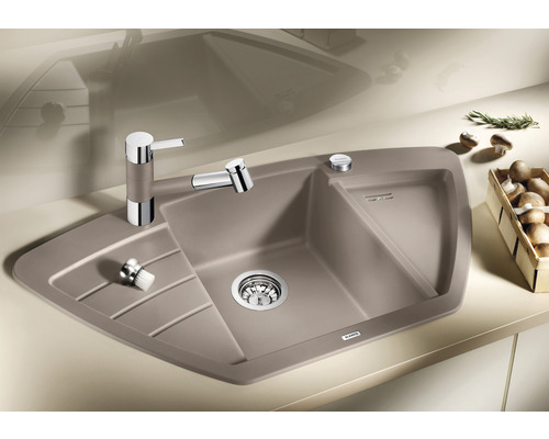 Eckspüle mit Abtropffläche, Armatur und Spülmittelspender auf einer Küchenarbeitsplatte.