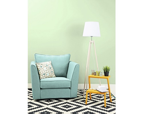 Salon avec fauteuil, coussin, lampadaire et tapis à motif géométrique