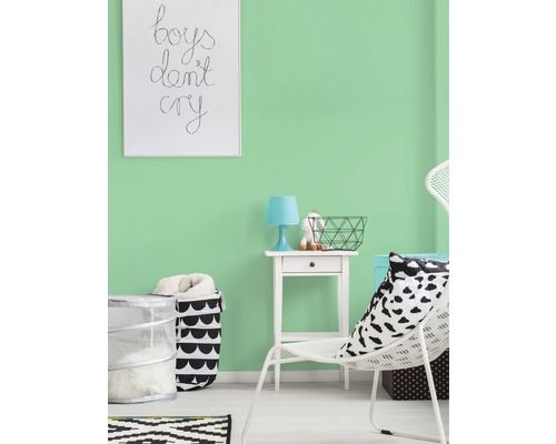Pièce lumineuse avec peinture murale vert menthe, décorée d''une chaise blanche, d''une table de chevet et d''un panier
