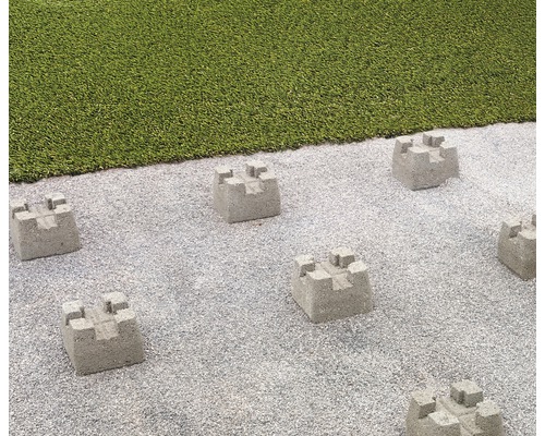 Scène avec des bordures de gazon en béton sur une surface de gravier à côté d''une pelouse