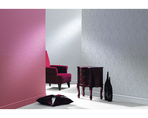 Salon avec papier peint à motifs, fauteuil et commode