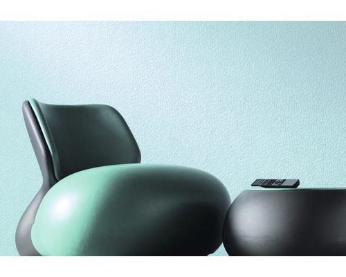 Scène avec fauteuil, table et télécommande devant un mur texturé