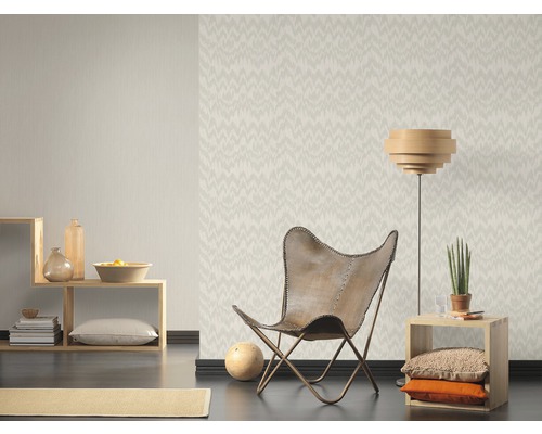 Salon avec papier peint à motifs, fauteuil et meubles en bois