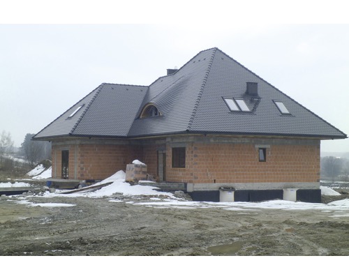 Maison inachevée avec façade en briques et toit en tuiles