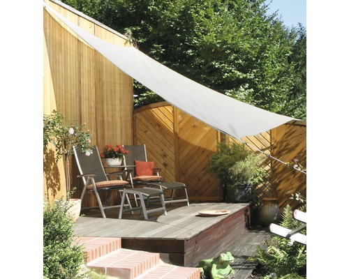 Voile d''ombrage au-dessus d''une terrasse avec des meubles de jardin comme parasol