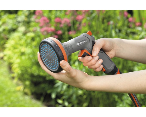 Une personne tient une douche Gardena dans sa main.