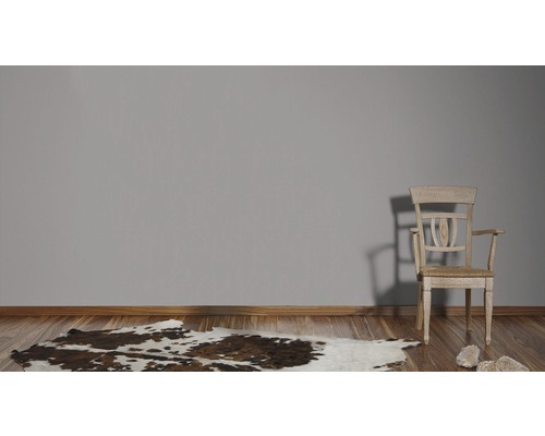 Zimmer mit Holzboden, Kuhfellteppich und Holzstuhl