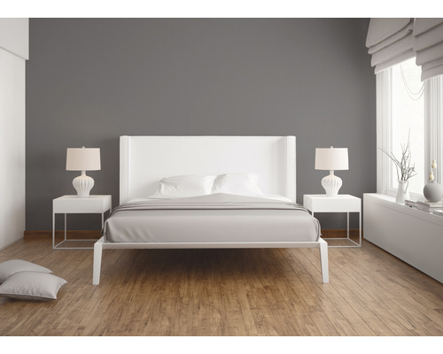 Helles Schlafzimmer mit weissem Bett, Nachttischen und Lampen auf Holzboden