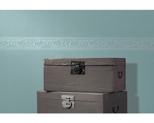 Deux coffres gris empilés devant un mur bleu avec une bordure