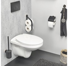 Salle de bains moderne avec WC suspendu, brosse de toilette, porte-papier toilette et serviette