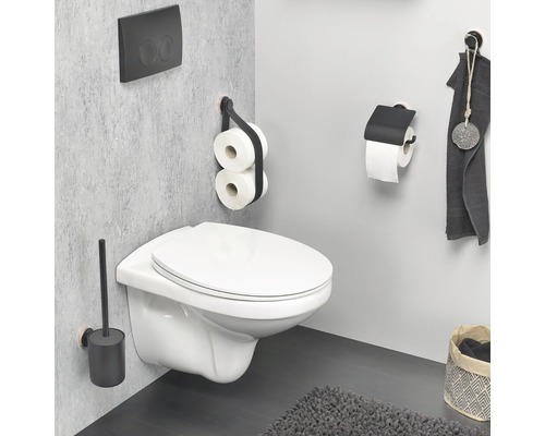 Salle de bains moderne avec WC suspendu, brosse de toilette, porte-papier toilette et serviette