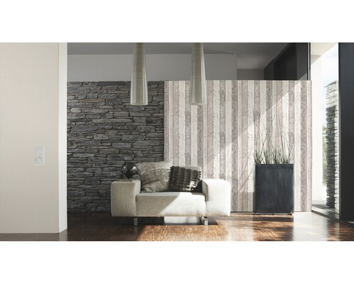 Wohnzimmer mit Sessel, Steintapete und dekorativer Trennwand