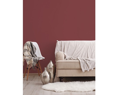 Scène de salon avec canapé, chaise, tapis et décoration devant un mur