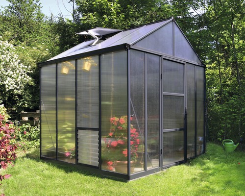 Gewächshaus aus Glas mit Tür und Lüftungsfenster im Garten.