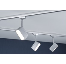 Trois spots sur un rail lumineux sous le plafond.