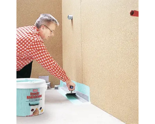 Une personne applique du mortier d''étanchéité avec une truelle, scellé avec du ruban d''étanchéité, seau au premier plan.