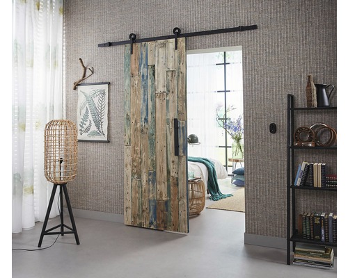 Pièce avec porte coulissante en bois, lampadaire et bibliothèque