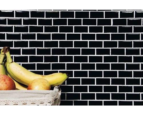 Mur avec des carreaux rectangulaires noirs et un panier de fruits