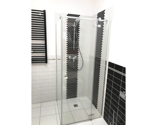 Douche à l''italienne avec paroi en verre et radiateur noir dans la salle de bains.